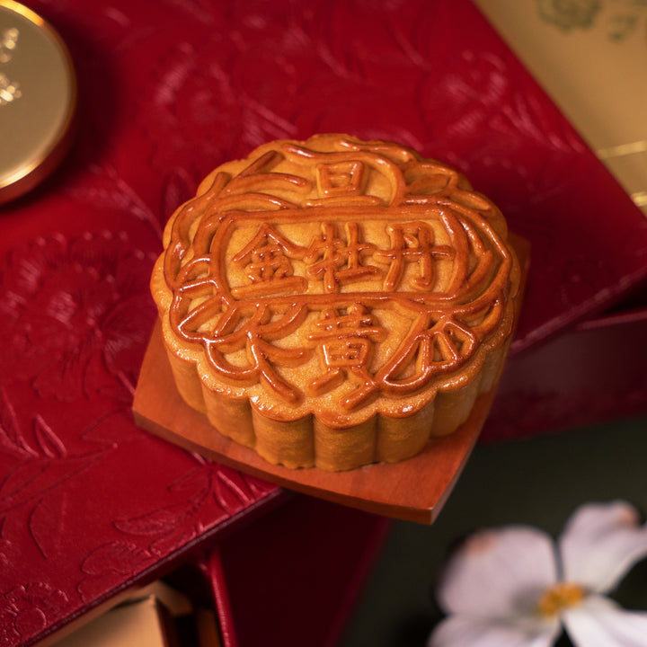 Mooncake with Chinese characters on a red textured surface